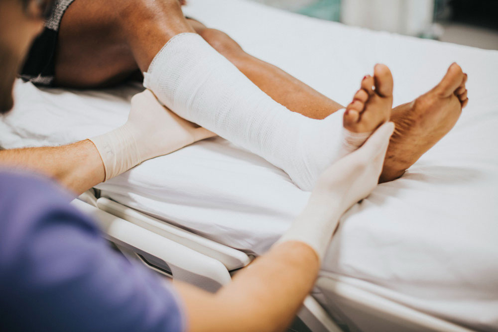 doctor helping patient with fractured leg auto accident auto accident,auto accident recovery,chiropractor near me,chiropractic care Wesley Chapel Spine and Sport Medicine