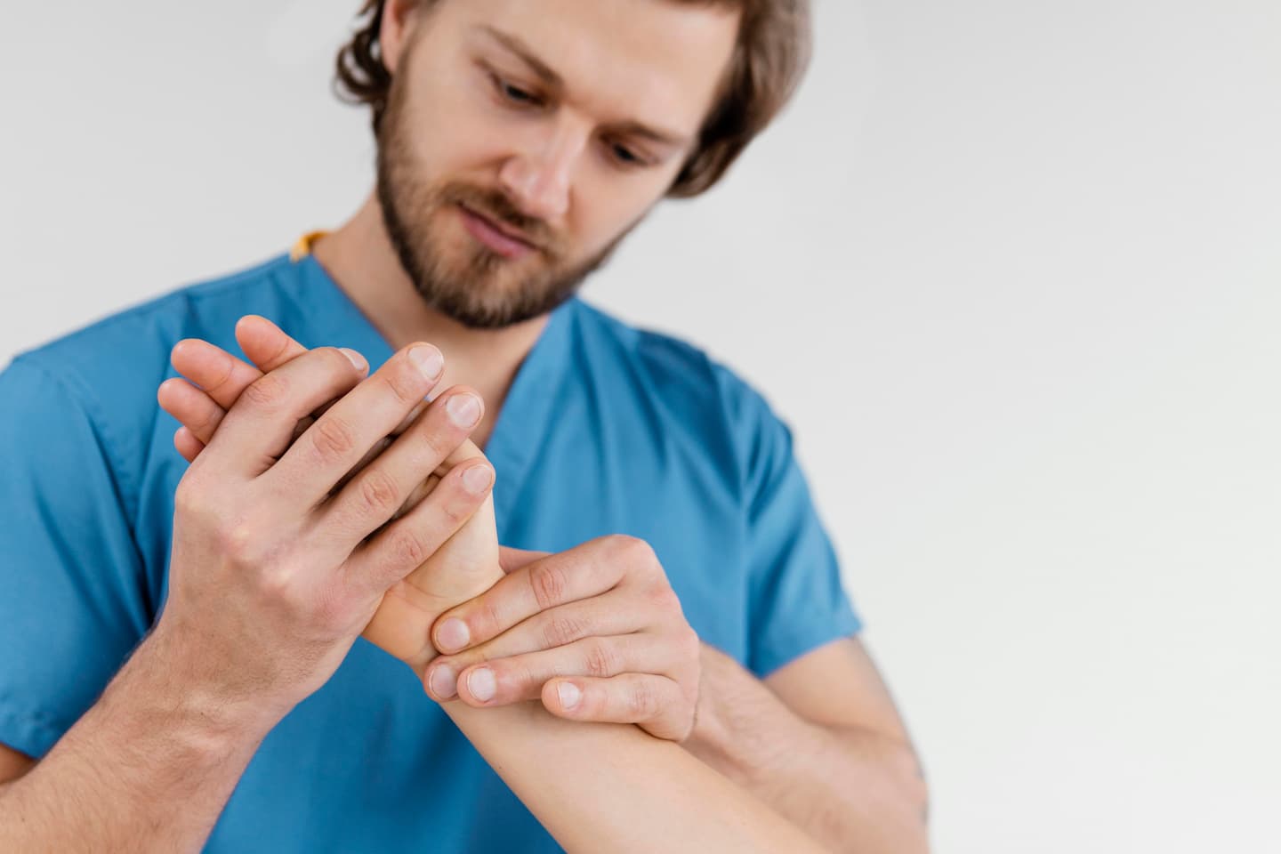 front view male osteopathic therapist checking female patient s wrist joint 1