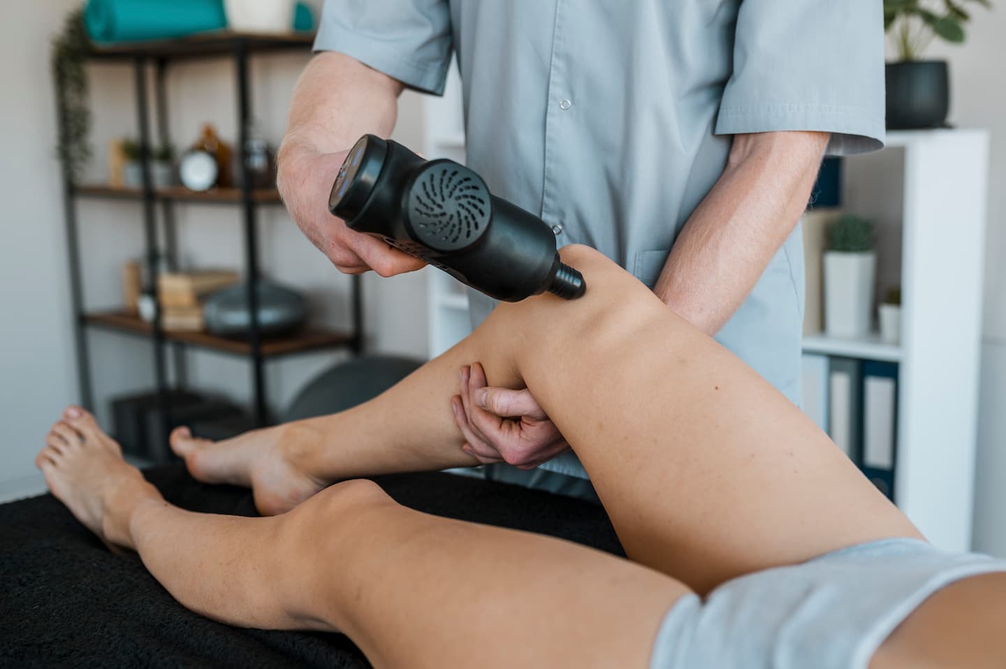 male physiotherapist using equipment female patient physical therapy session 1